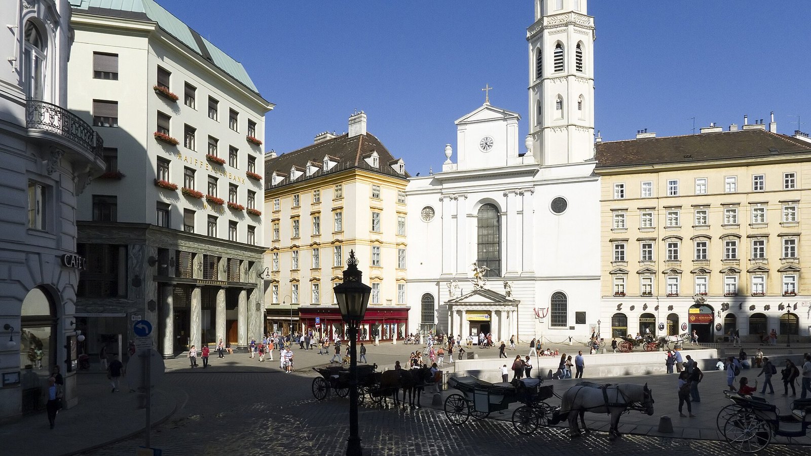 Fiaker horse-drawn cabs waiting on Michaelerplatz in central Vienna under a clear sky